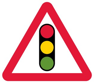 A white triangle with a red border and a traffic light showing red, amber and green